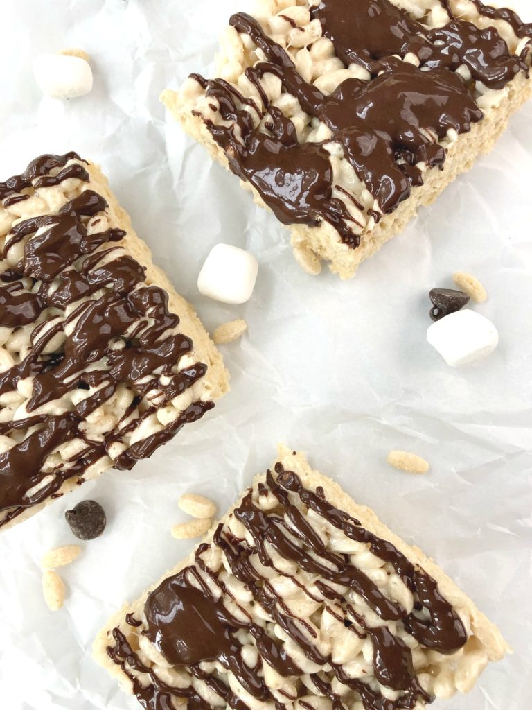 Three squares of gluten-free Rice Krispy Treats covered in drizzled chocolate