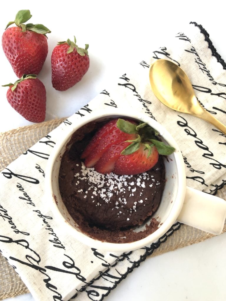Gluten-Free chocolate mug cake pictured with powdered sugar and strawberries