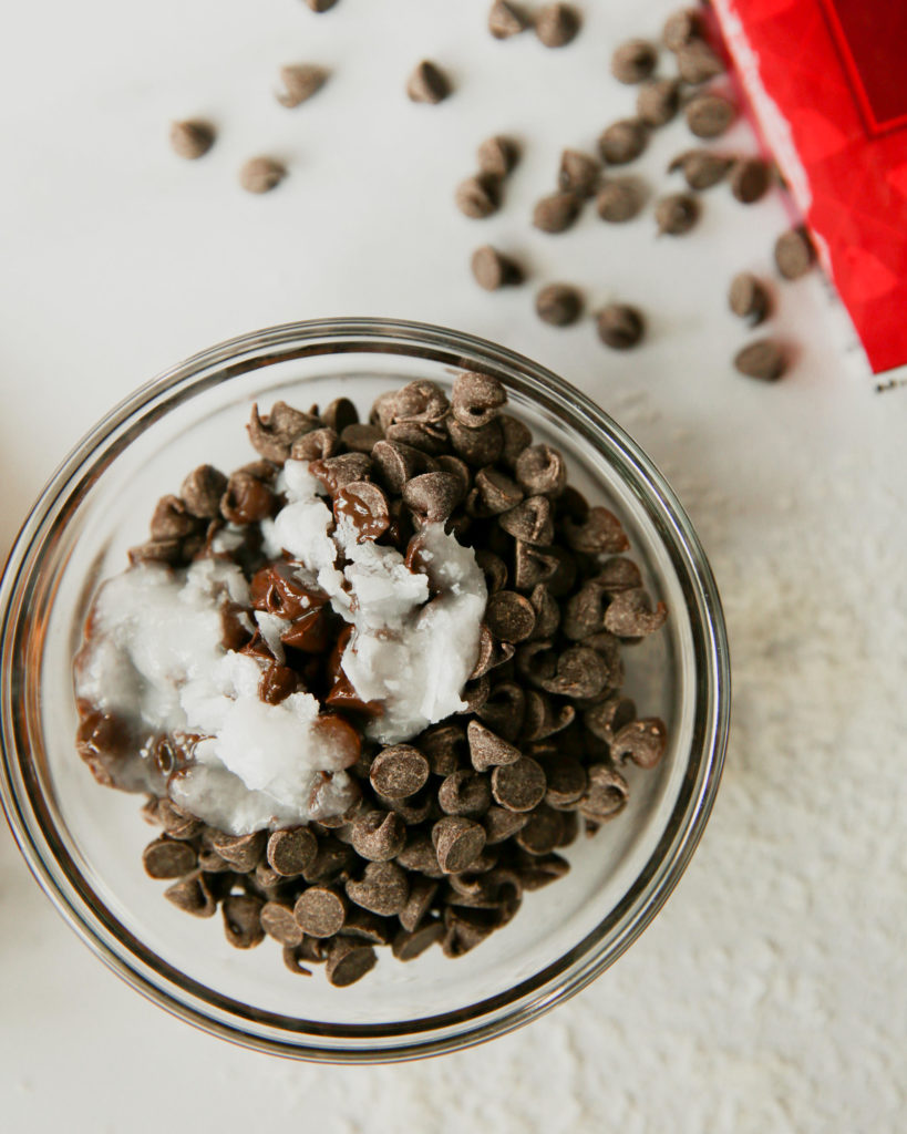 Chocolate chips and coconut oil combined in a bowl