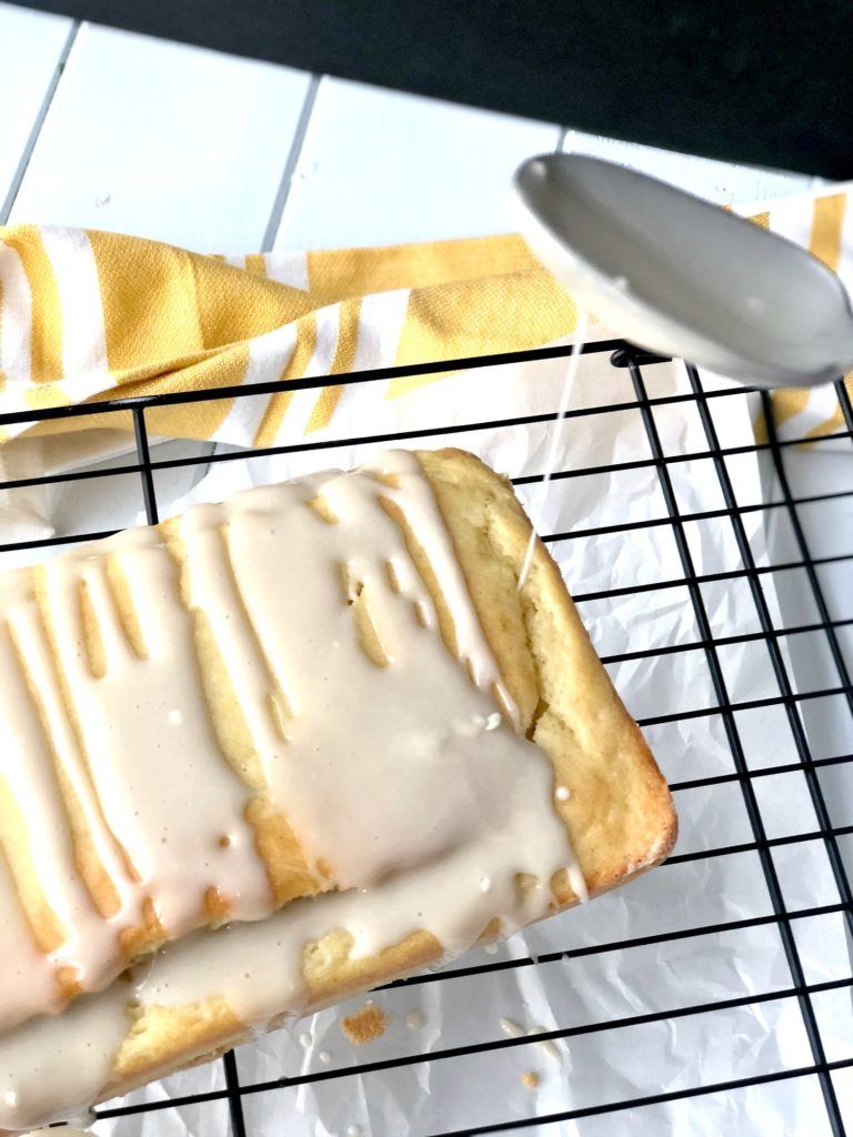 Drizzling icing atop gluten-free lemon vanilla pound cake