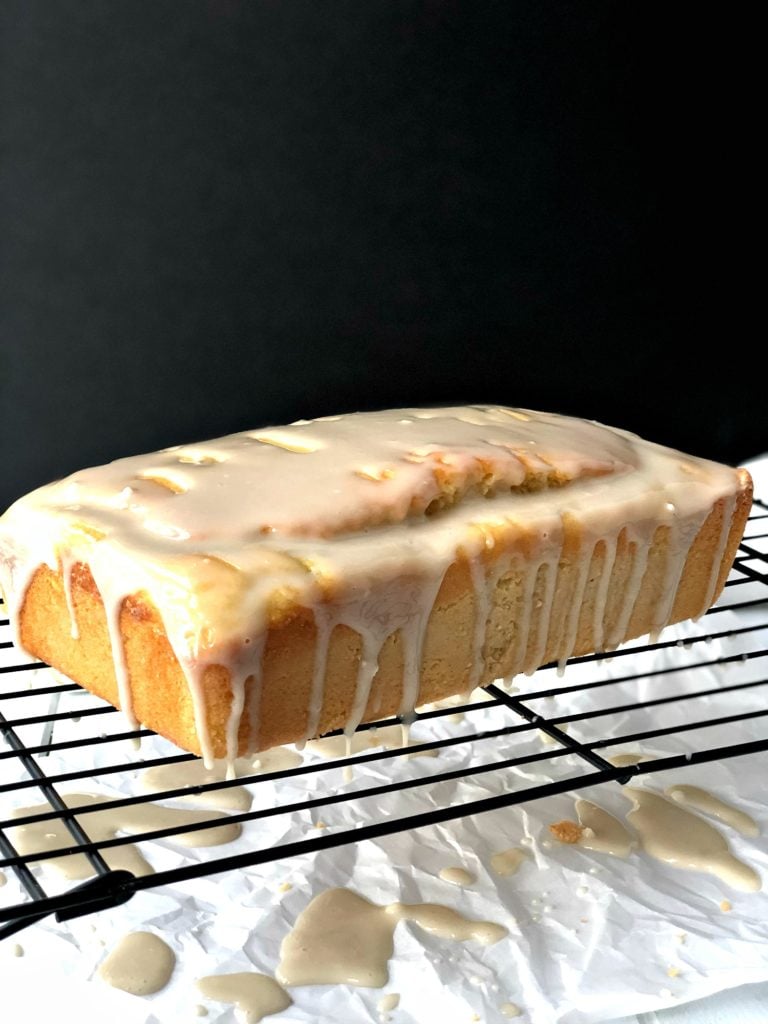 Gluten-Free lemon vanilla pound cake with icing dripping off sides