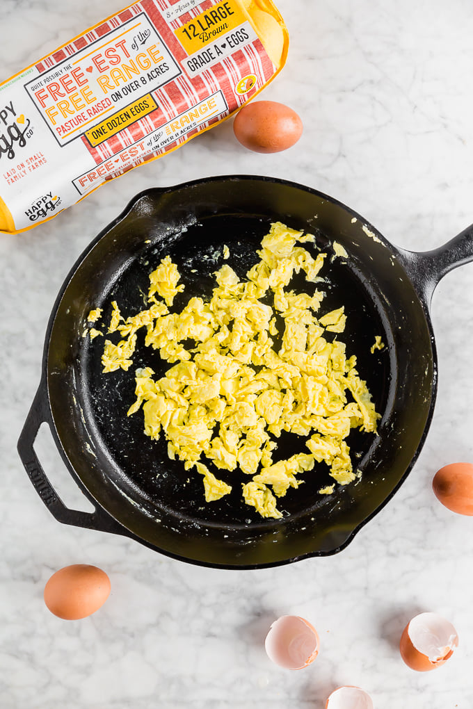 scrambled eggs in a pan with happy eggs package