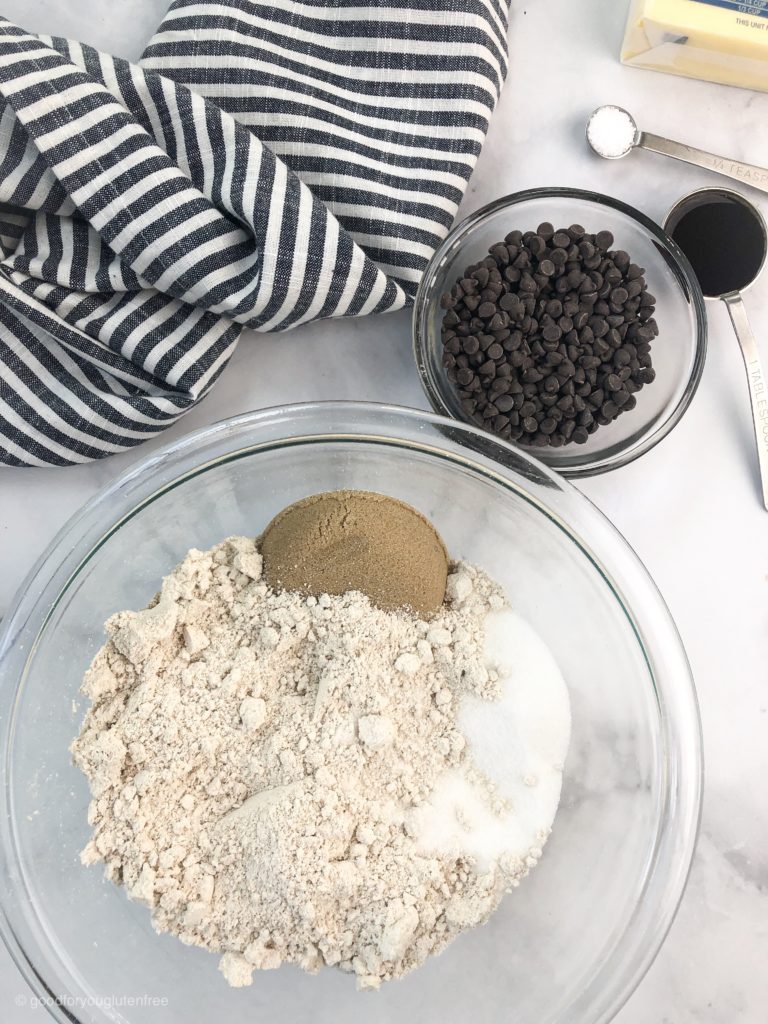 a bowl with oat flour, sugar and salt ready to be made in to gluten-free chocolate chip cookie dough balls