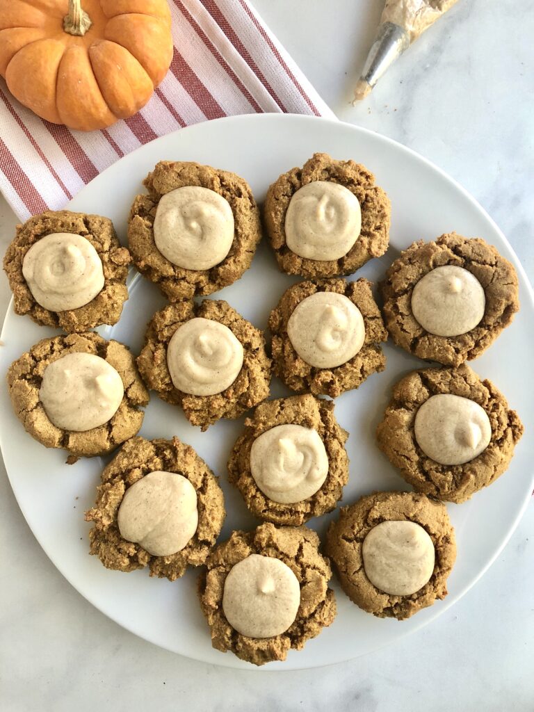 A ton of pumpkin cookies on plate.