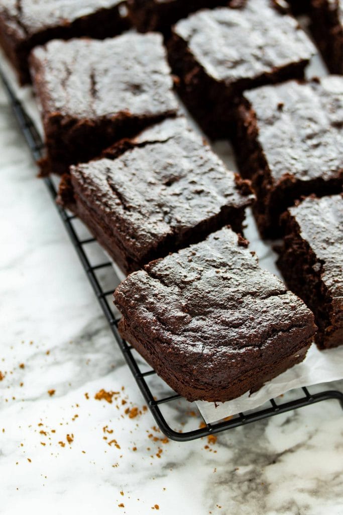 Pictured of squares of quinoa chocolate brownie cake on a cooling rack. Recipe by The Recipe Well.