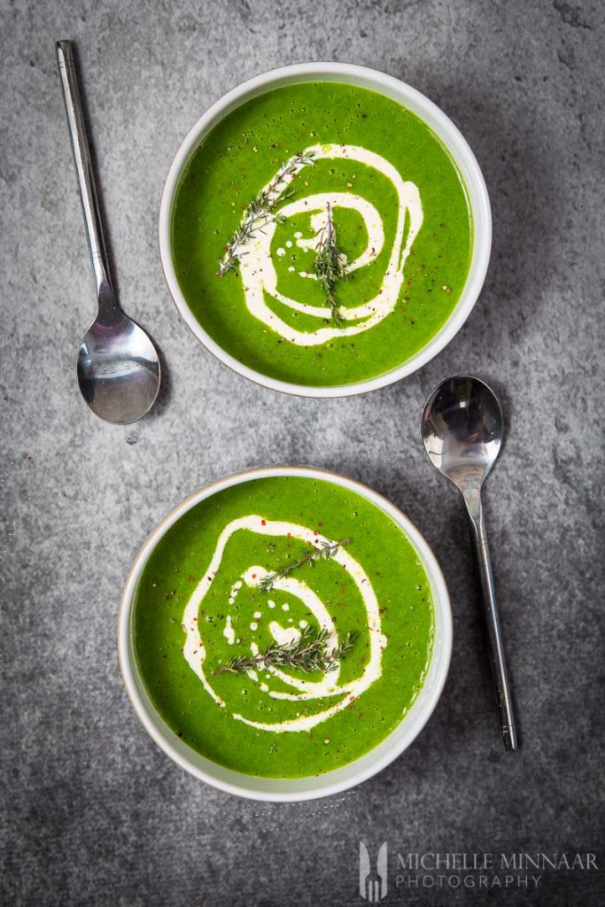 Beautiful green watercress soup with swirls of white cream inside.