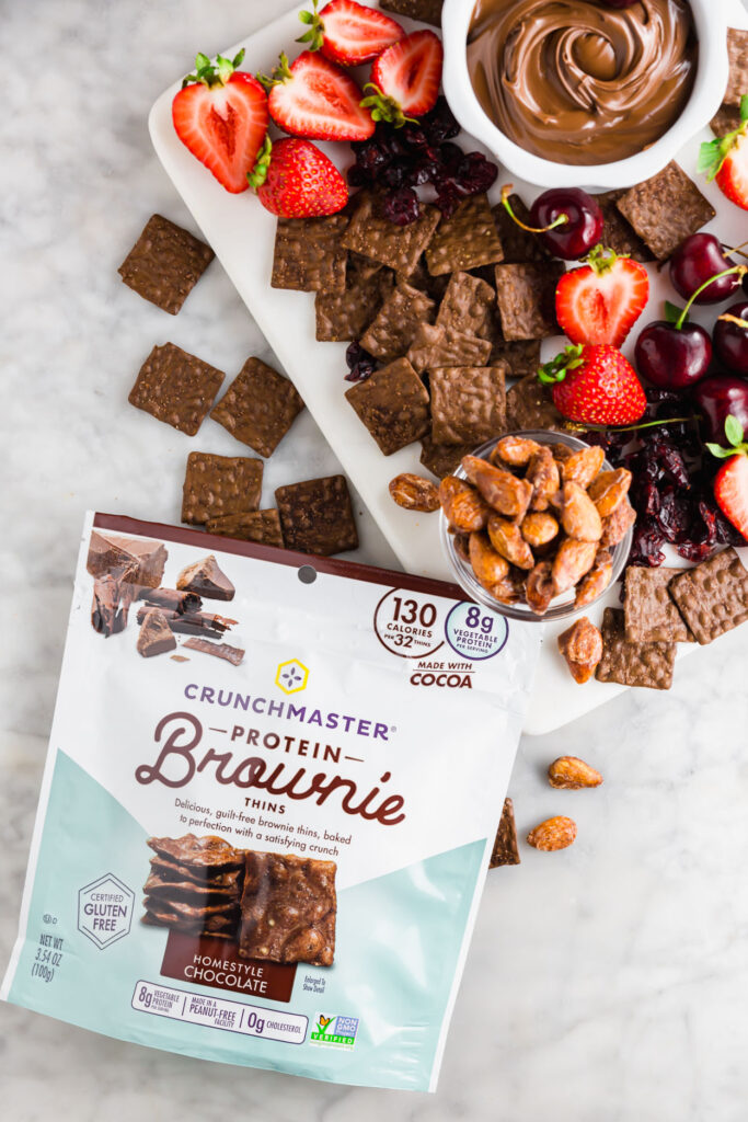 Overhead image of chocolate-themed snack board and picture of Crunchmaster protein brown thin crackers
