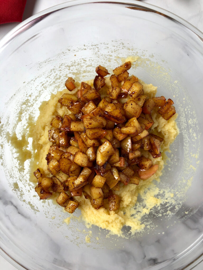 Pictured of the cooked apples on top of the almond flour batter, ready to be mixed together.