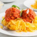 Picture of spaghetti squash on a plate topped with meatballs and sauce