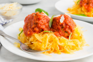 Picture of spaghetti squash on a plate topped with meatballs and sauce