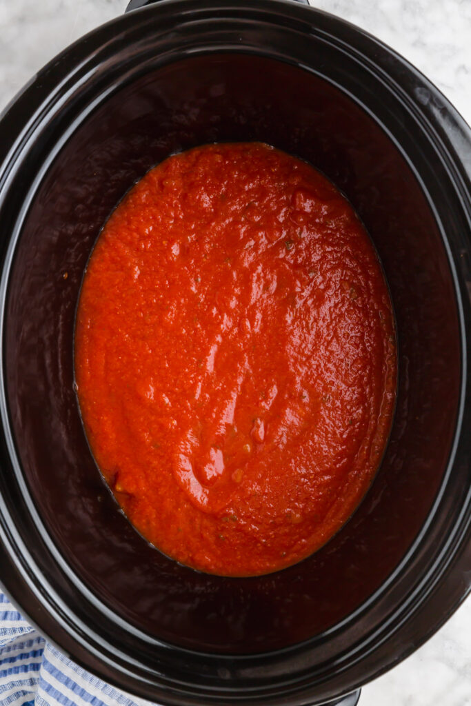 Picture of slow cooker with marinara sauce in it