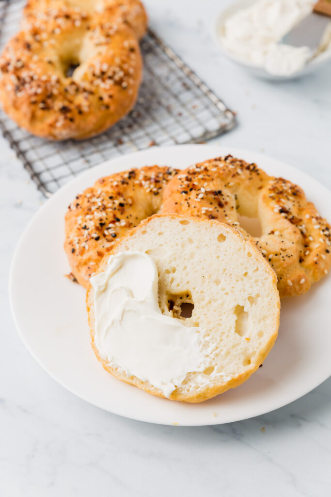 Close up of bagel sliced in half and smeared with cream cheese