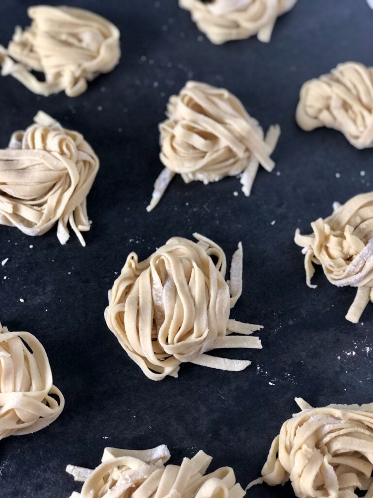 Picture of two ingredient gluten-free pasta cut into linguine noodles and on a black tray