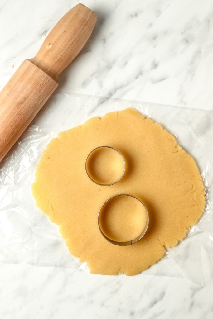 almond flour dough rolled out and cookie cutter circles