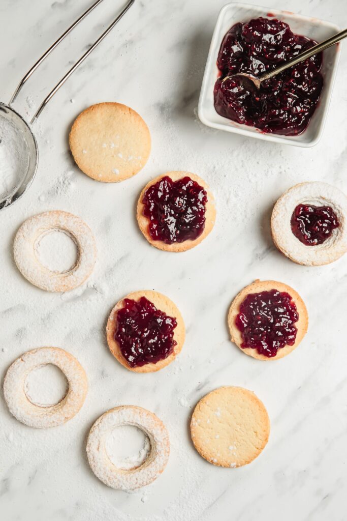 Cookies being covered in jam