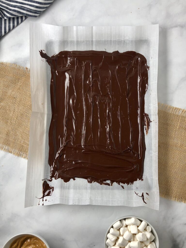 Pictured of melted chocolate smeared on parchment paper