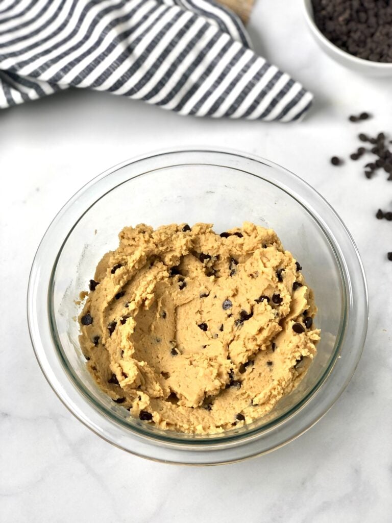 Picture of edible cookie dough in a bowl with the mini chocolate chips mixed in.