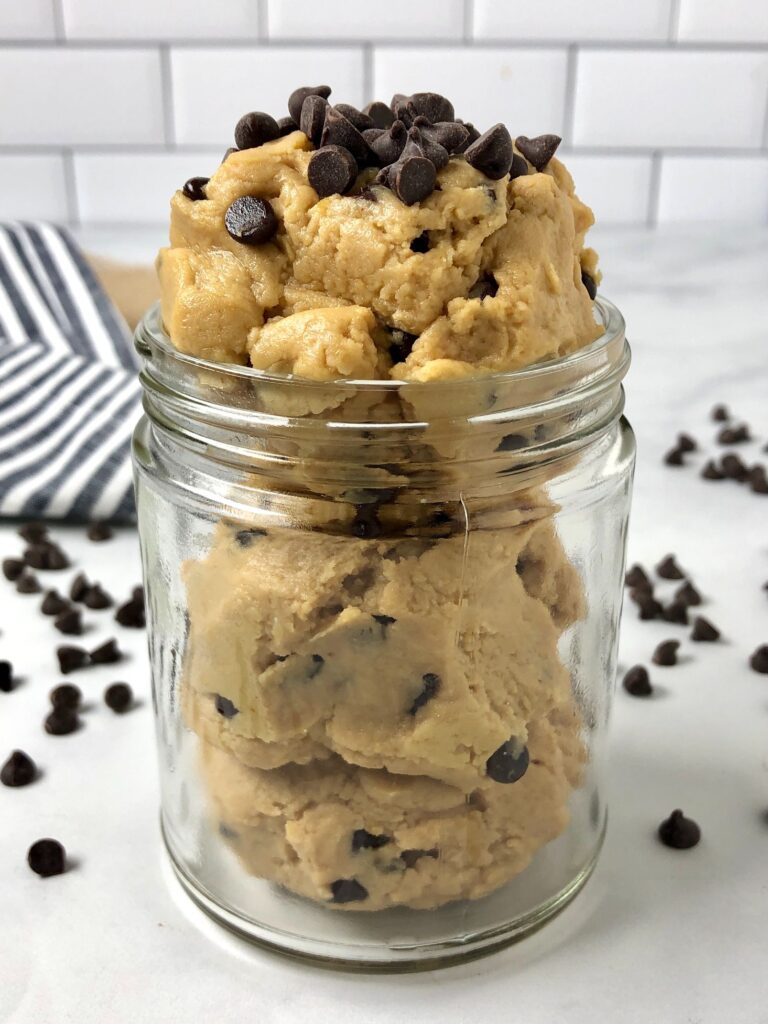 Close up image of assembled edible cookie dough overflowing with mini chocolate chips.