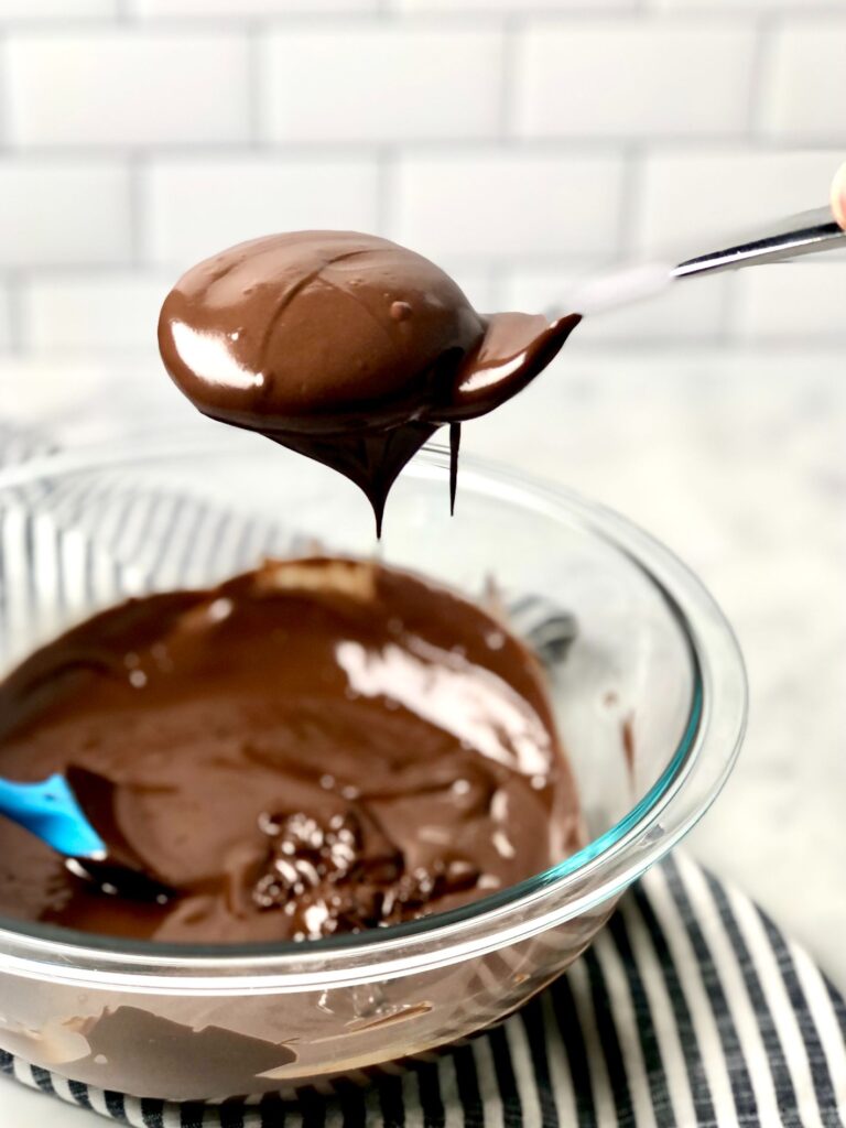 Coating the Thin Mints with chocolate over a bowl of melted chocolate