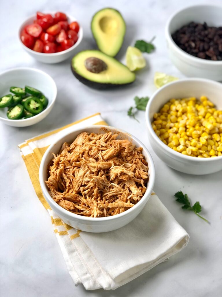 Picture of shredded chicken and other ingredients needed for the fresh chicken enchilada bowls