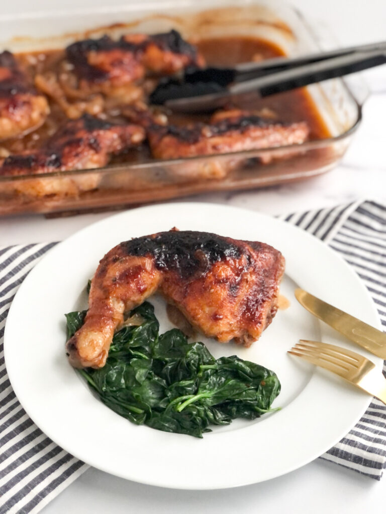 Baked BBQ Coke Chicken on a plate with spinach