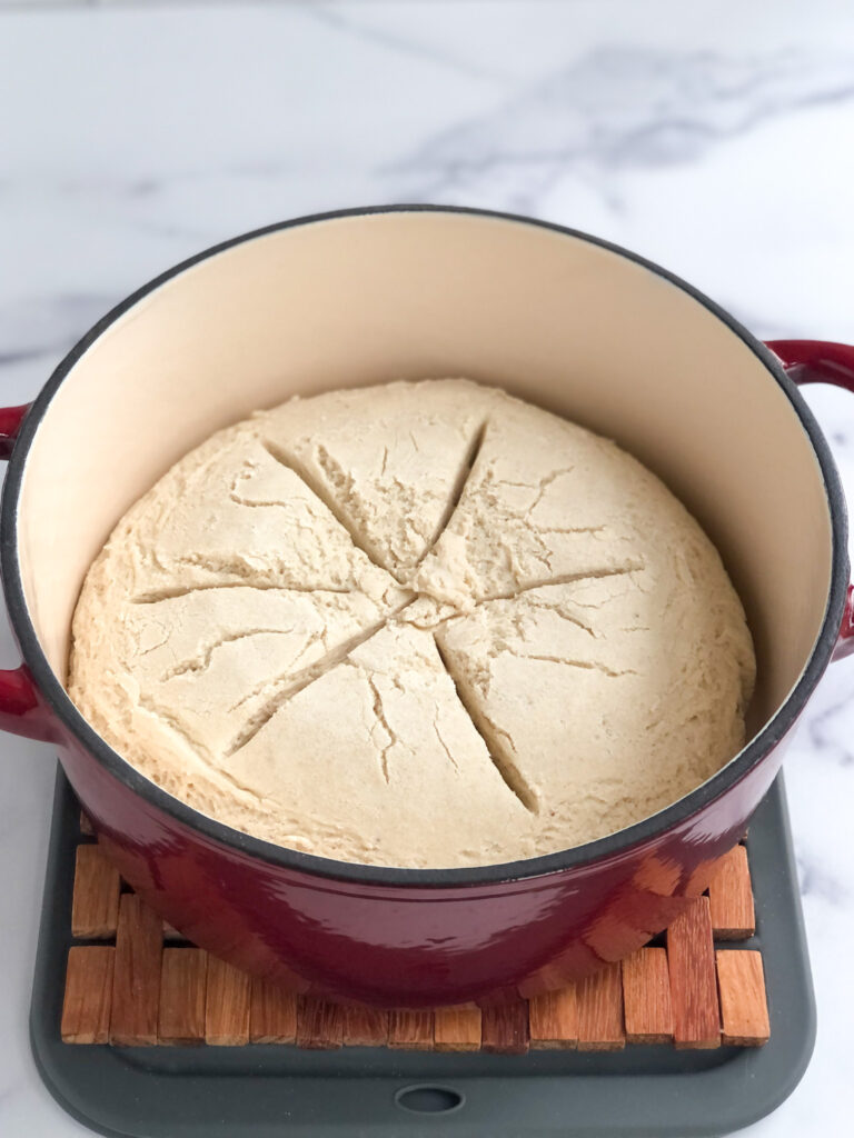 Dough inside Dutch oven and scored in a decorative way