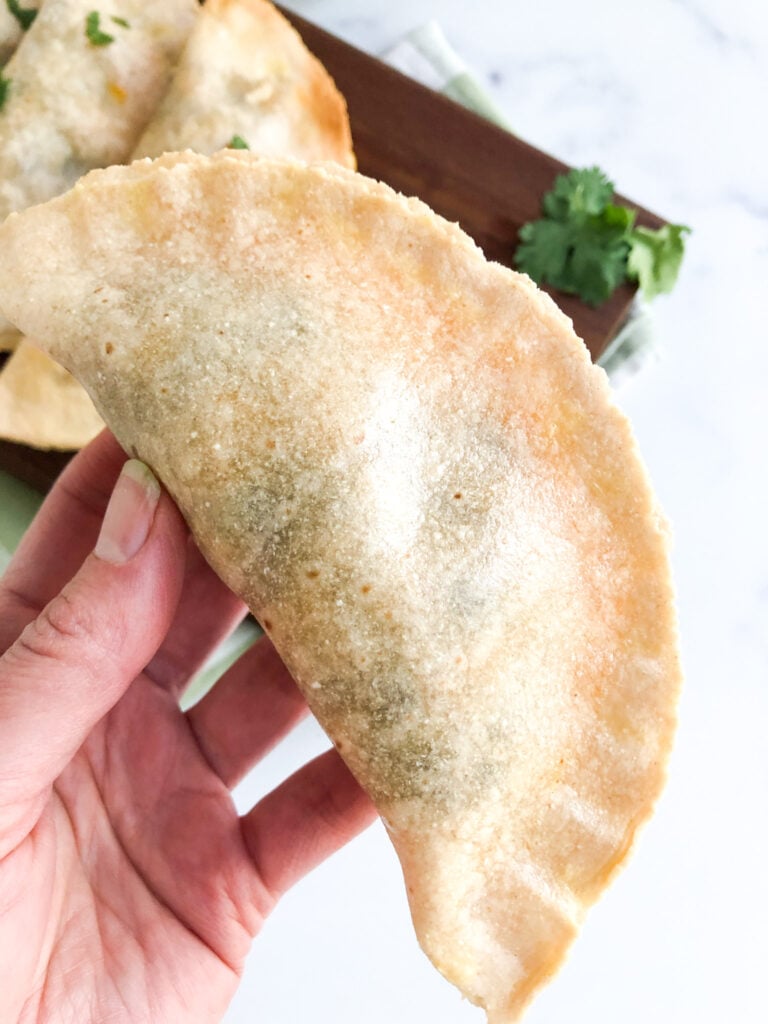 Hand holding a gluten-free empanada