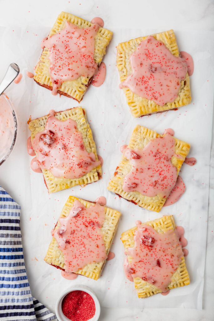 All 6 gluten-free pop tarts covered with cherry glaze and red sugar sprinkles