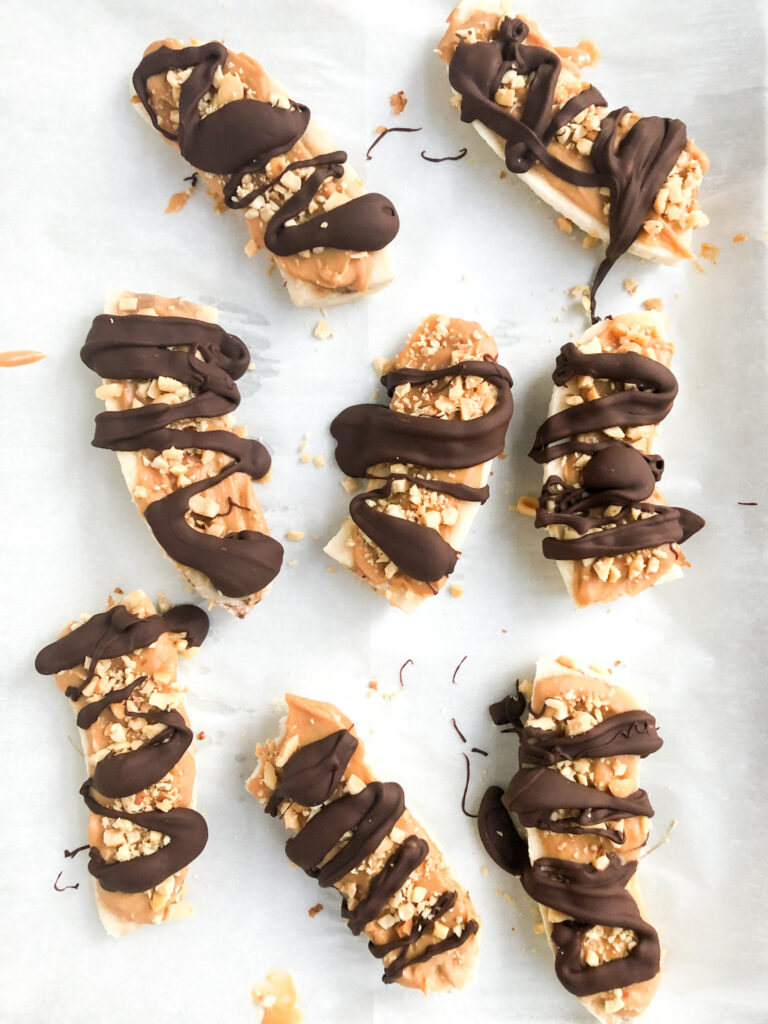 Frozen healthy Snickers made with bananas, peanut butter, crushed peanuts and chocolate