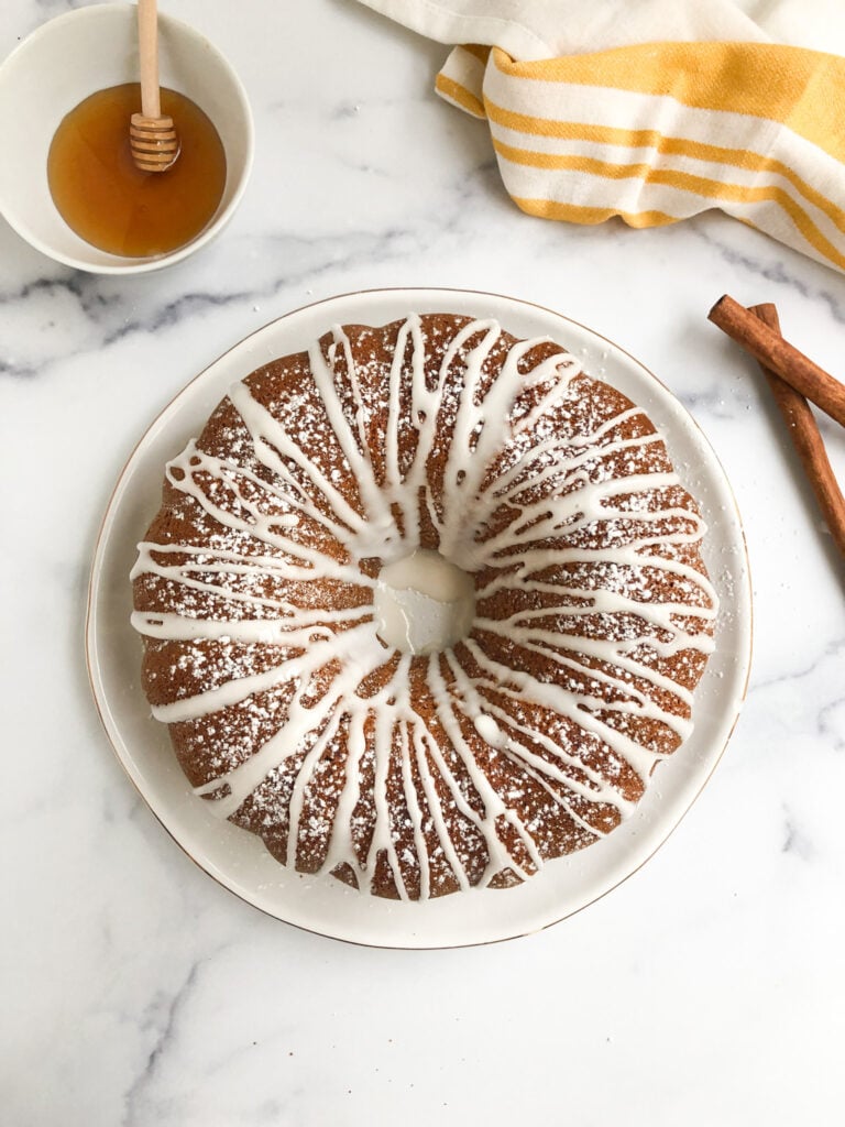 gluten-free honey cake frosted with a side of honey and cinnamon sticks