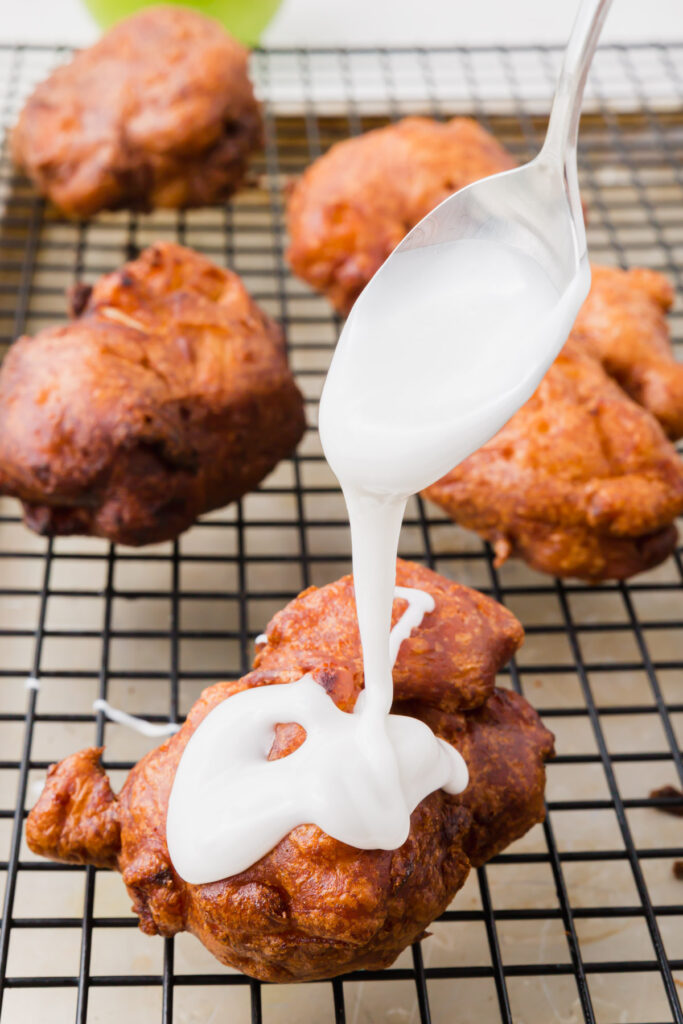 Pouring glaze on cooked apple fritters