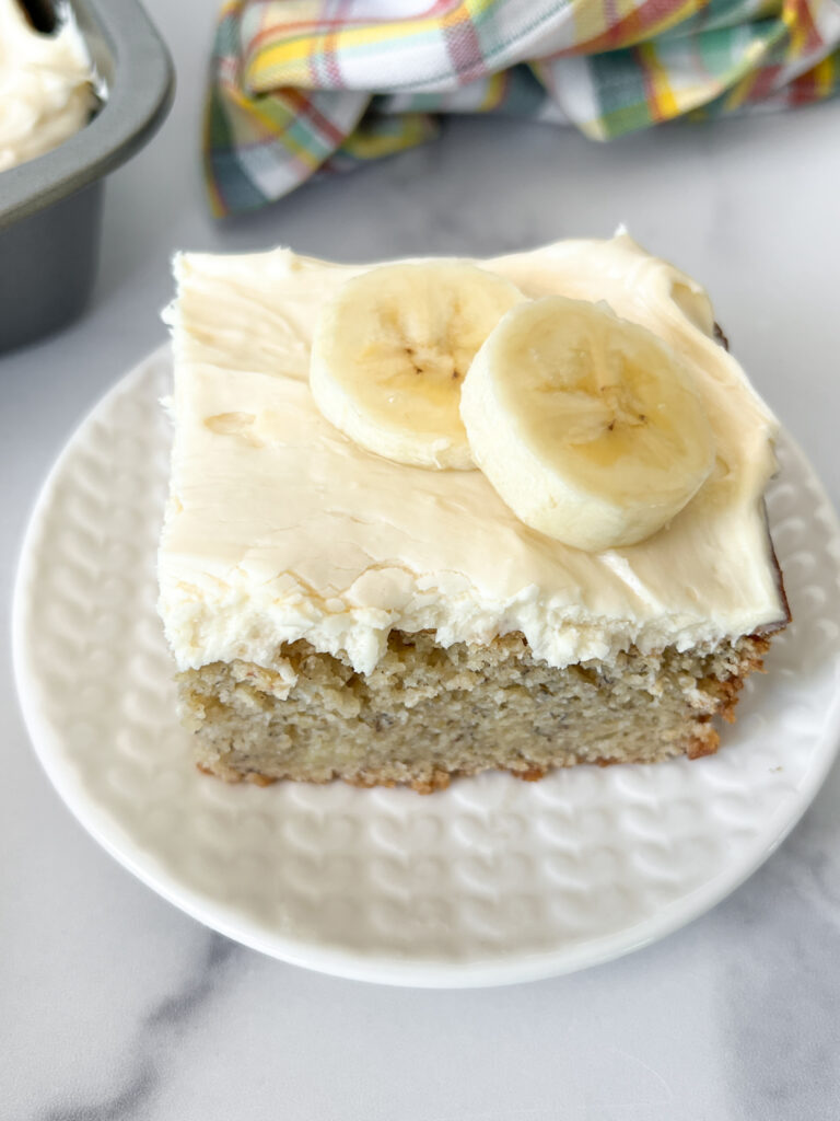 slice of gluten-free banana cake on a plate with banana slices on top