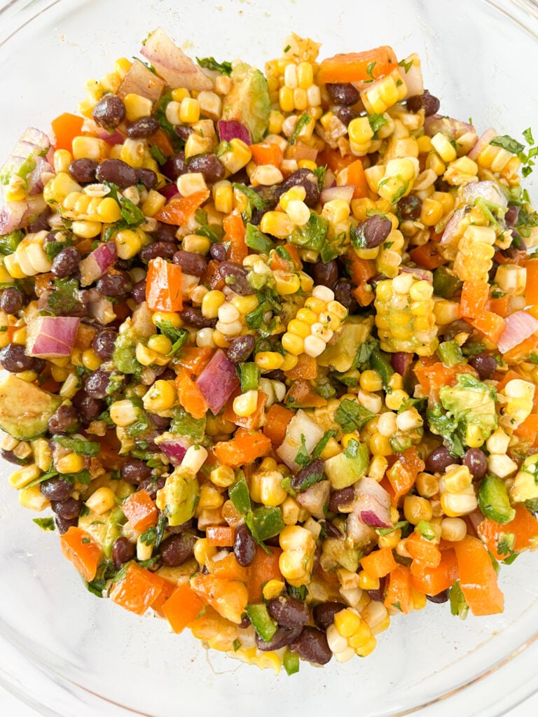 overhead pic of black bean and corn salad with chipotle lime dressing added