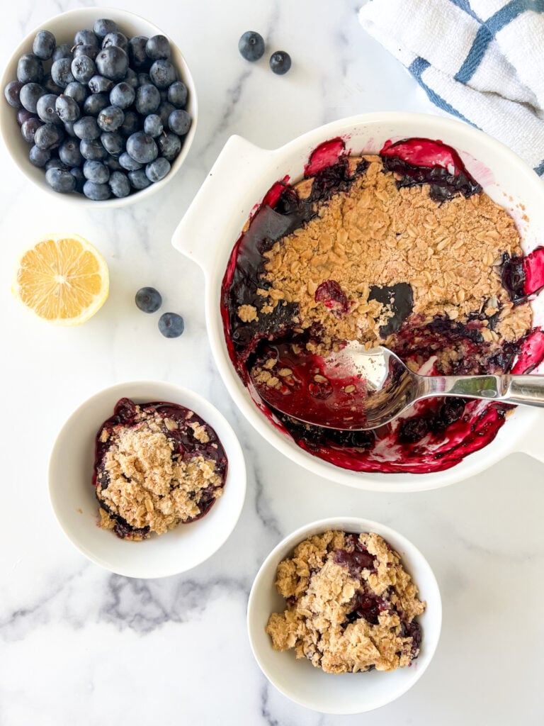 Gluten-free blueberry crisp baked with two scooped out portions