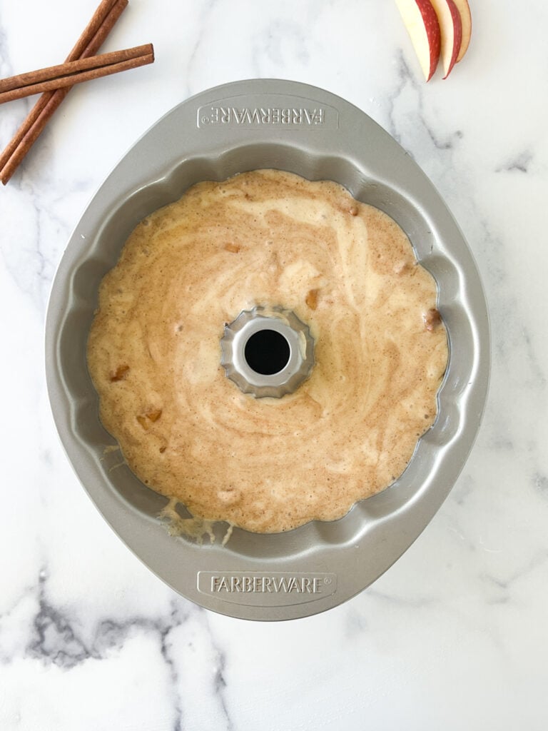 unbaked apple cake batter inside bundt pan