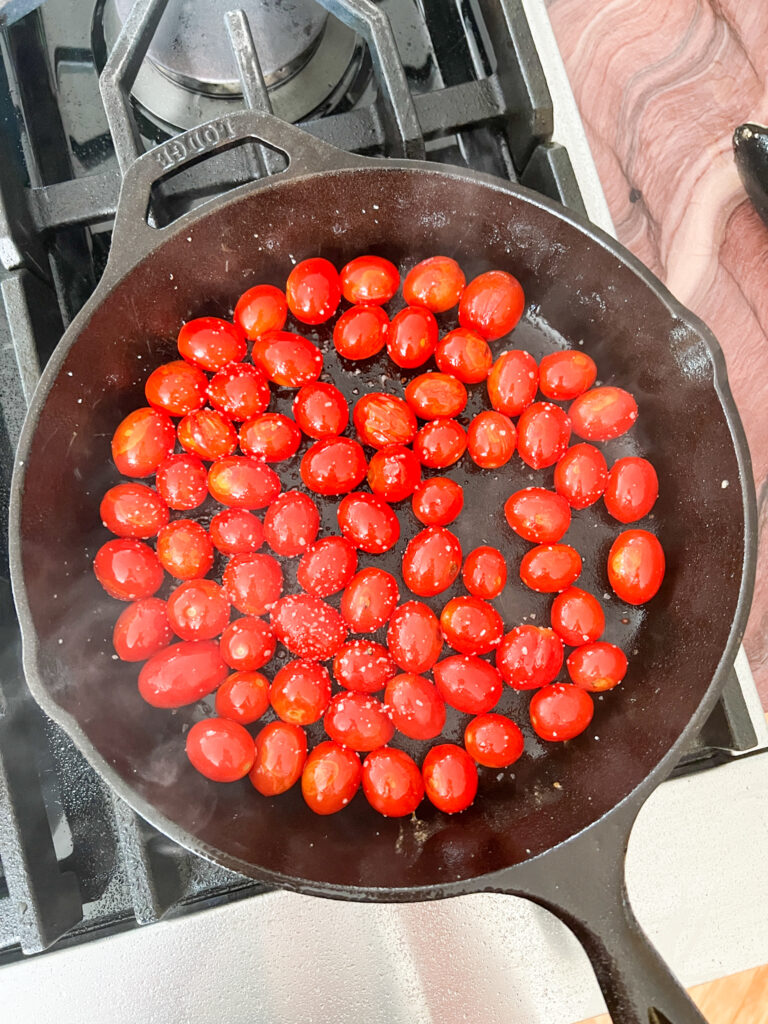 grape tomatoes cooking in a cast iron pan