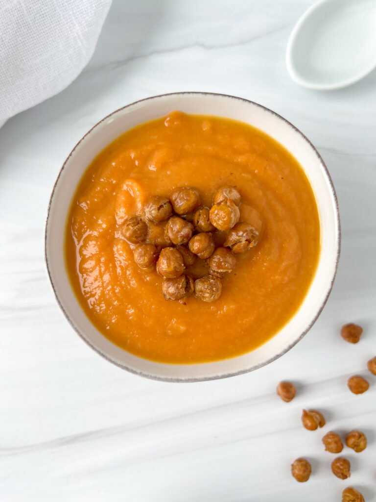bowl of carrot and cauliflower soup with crispy chickpea topping