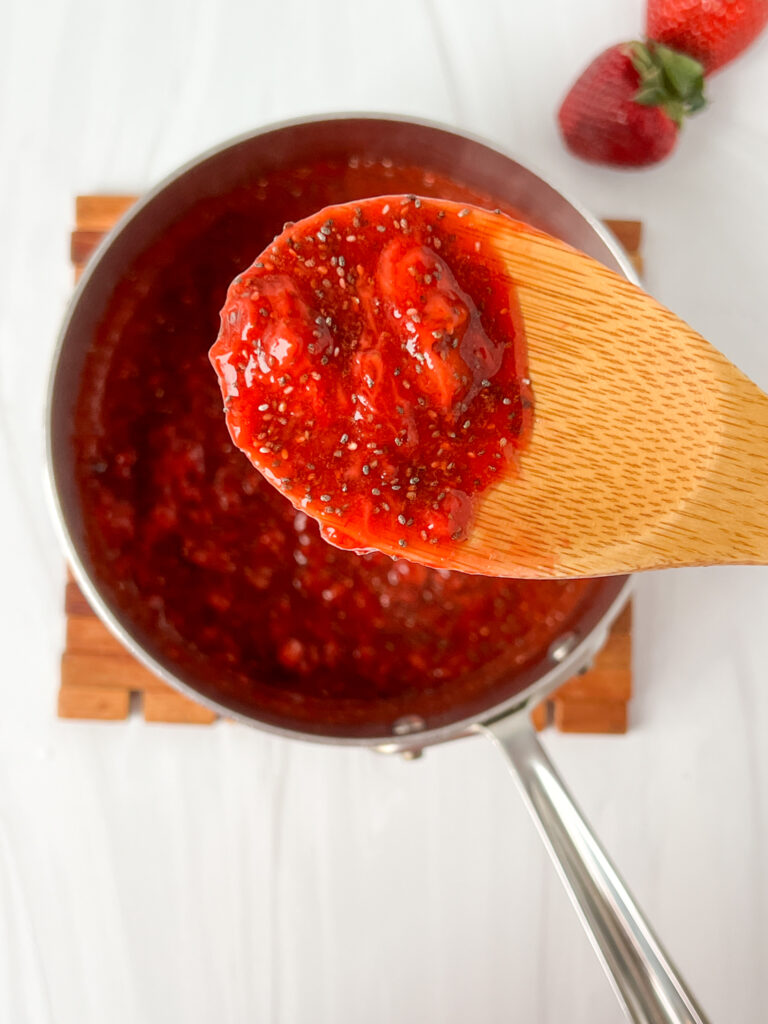 close up of strawberry chia jam on wooden spoon