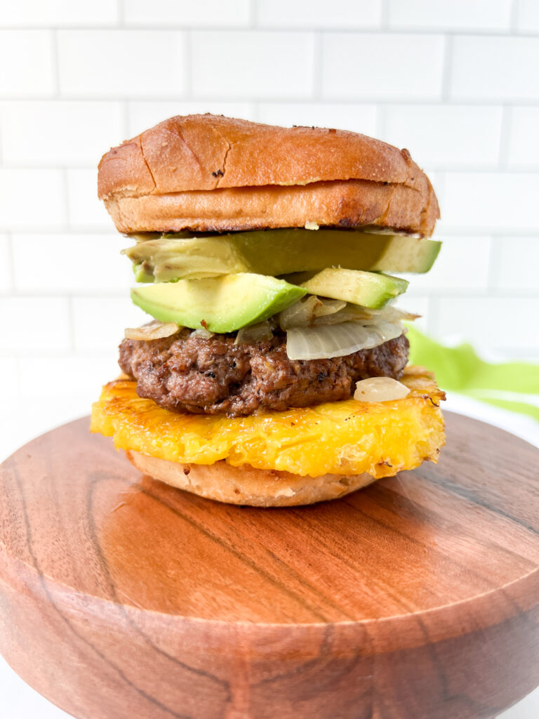 Hawaiian burger stacked with pineapple, avocado, onions and a beef patty