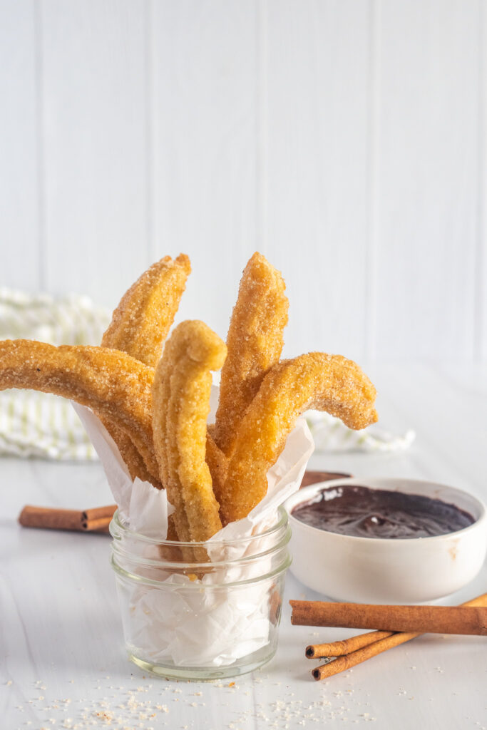 gluten-free churros in a serving cup with chocolate ganache