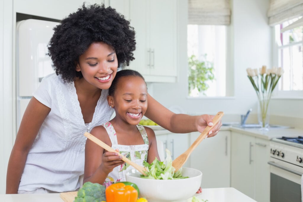 healthy mom and daughter making a salad